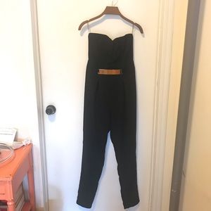 Sleeveless black jumpsuit with gold buckle